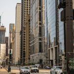 cars on road between high rise buildings during daytime
